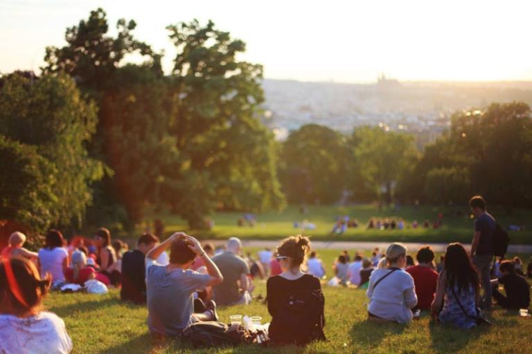 Picture of a group of people sat in a park on a sunny day